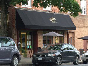 Street view of a café with cars parked.
