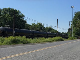 Train cars on tracks beside a road.