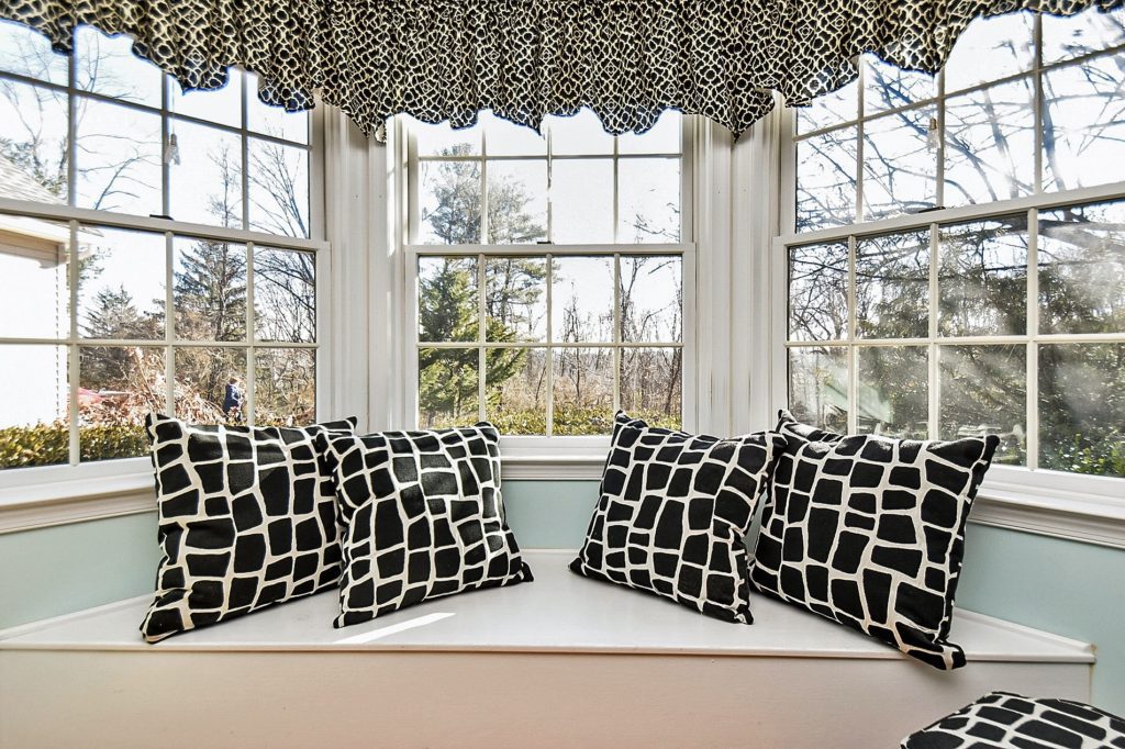 Window seat with patterned black cushions.