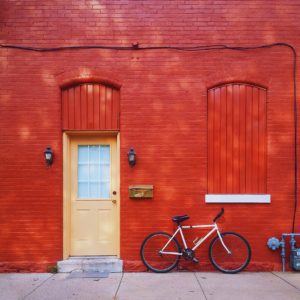Red brick wall with bicycle and door.