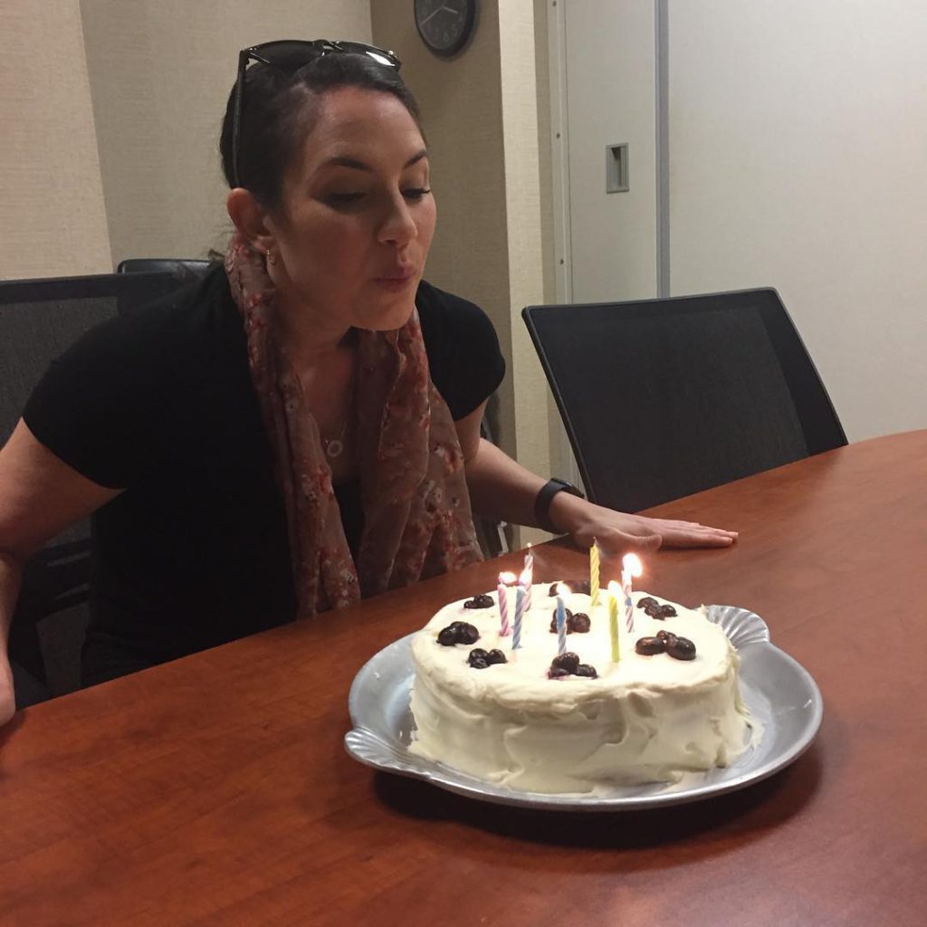 Woman blowing candles on birthday cake.