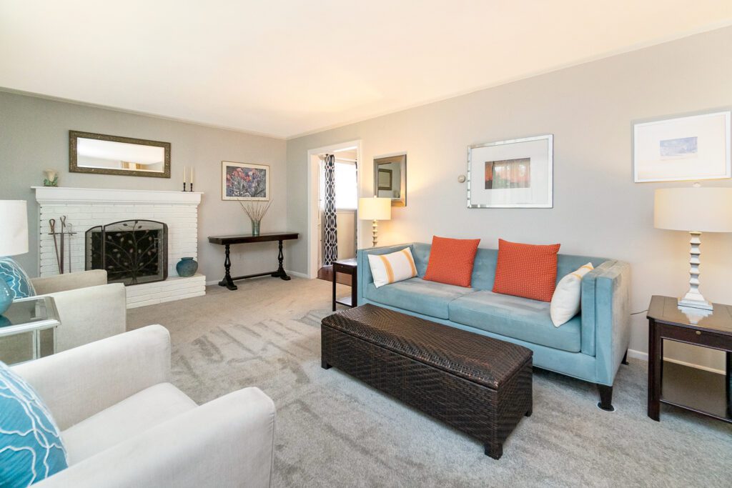 Modern living room with blue and orange accents.